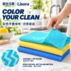 Colored Folded Kitchen Cloths — Viscose & PET Blend A hand lifts the corner of a turquoise patterned cloth above yellow and blue folded nonwoven cleaning sheets, with a detail view of the viscose-PET material.