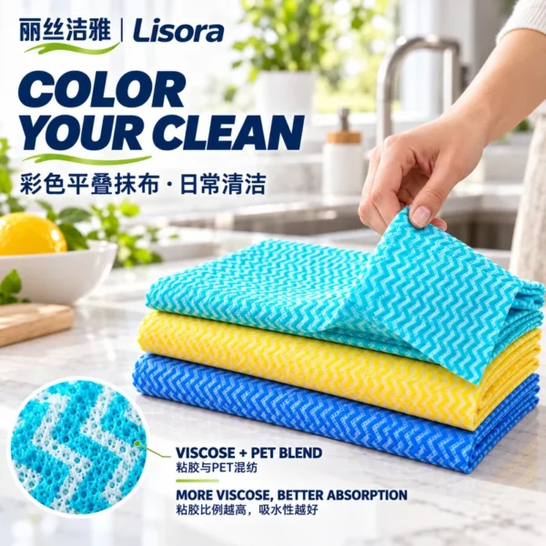 Colored Folded Kitchen Cloths — Viscose & PET Blend A hand lifts the corner of a turquoise patterned cloth above yellow and blue folded nonwoven cleaning sheets, with a detail view of the viscose-PET material.