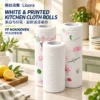 One plain white and two pink-and-green printed PP nonwoven kitchen cloth rolls stand on a bright countertop, showing their cores and surface texture.